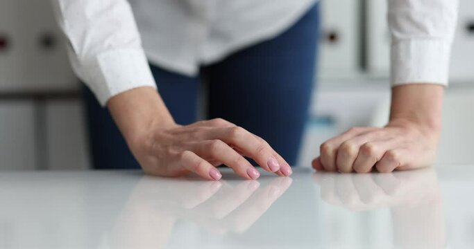 Hand of business woman taps fingers on table closeup