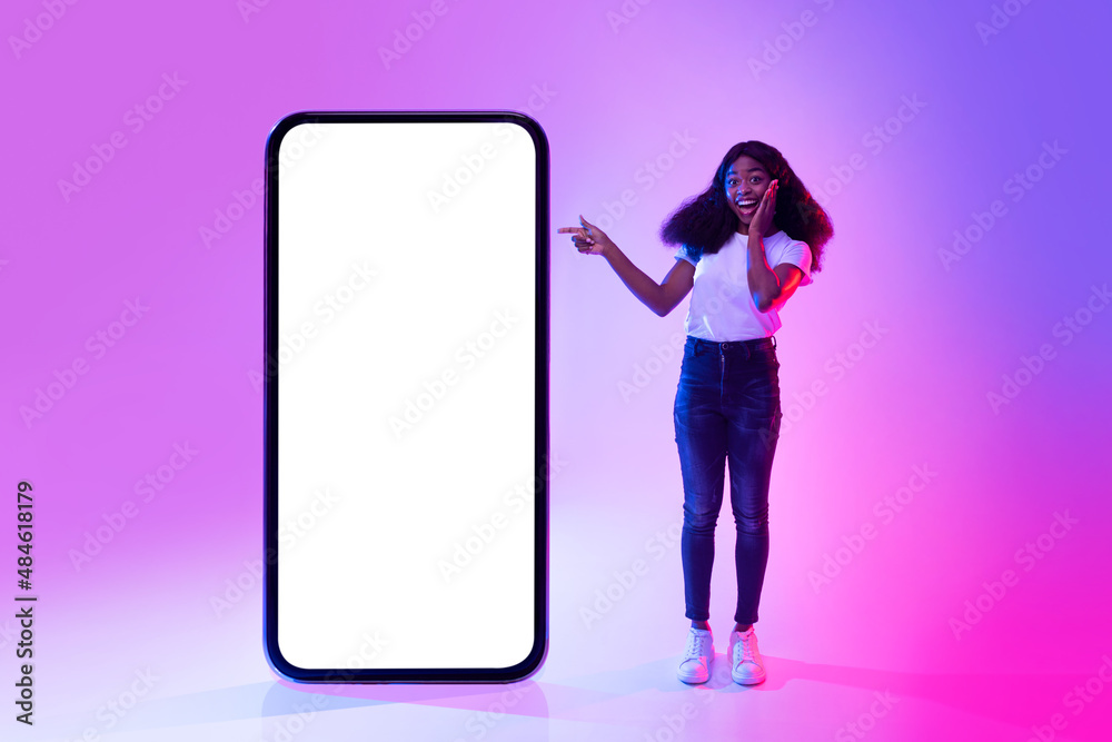 Poster excited black lady pointing at big cellphone with empty white screen, promoting new app or website i