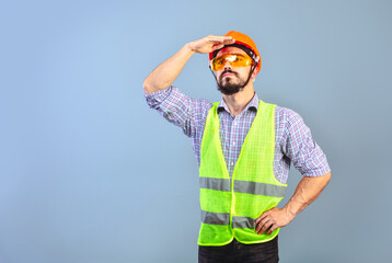 Pumped up supervisor wearing hard hat looking into the distance.