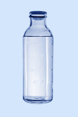 A glass medical bottle with a stopper. Filled with liquid on a blue background