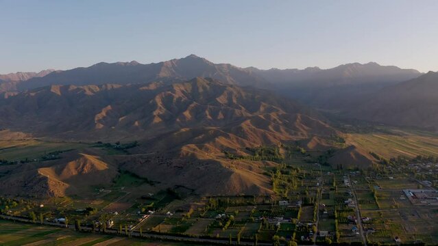 Collines et montagnes au bord du lac Issykul au Kirghizistan, soleil couchant.