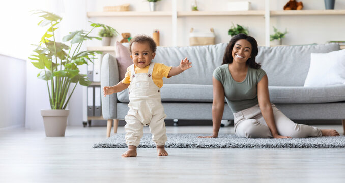 Portrait Of Adorable African American Infant Boy Making First Steps At Home