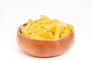  Uncooked pasta in wooden bowl on white background.