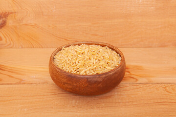 Barley noodle in the wooden plate on wooden background.