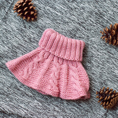 Pink knitted hat on a gray background