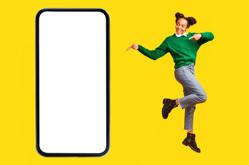 Fototapeta na wymiar African Teenager Girl Pointing At Blank Phone Screen, Yellow Background