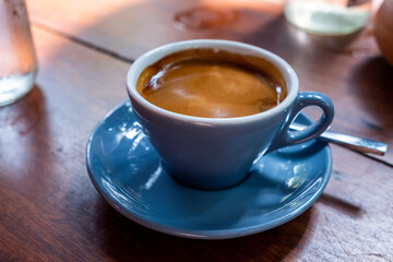 hot coffee in a blue cup on wooden table
