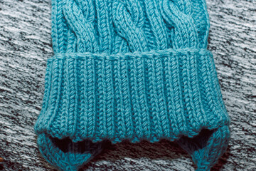 Blue knitted hat on a gray background