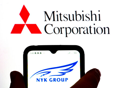 In this photo illustration, the Nippon Yusen Kabushiki (NYK) Group logo is displayed on a smartphone screen with a Mitsubishi Corporation logo in the background.