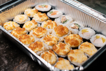Japanese food restaurant.  Sushi roll set in warm food container. Food delivery.