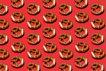 Colorful pretzel pattern against red background. Popular baked goods. Traditional German recipe. 