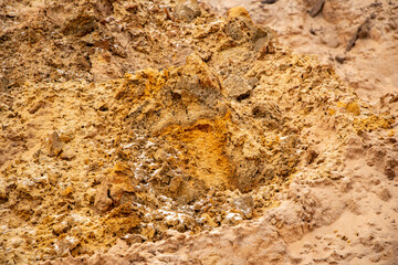 Textural sand, with  relief surface, multi-colored layers and different in size of granules, in outdoor sand career, after mining ore and sand for construction.