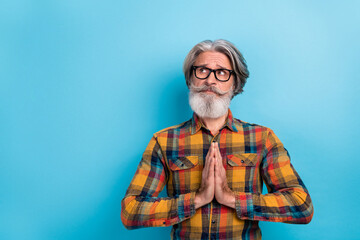 Photo of mature man hands together look empty space ask pleading expect isolated over blue color background