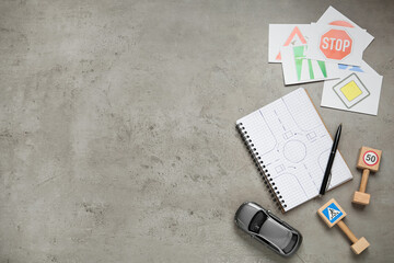 Many different road signs, notebook and toy car on grey background, flat lay with space for text....