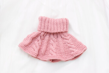 Pink knitted scarf on a white background