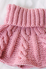 Pink knitted scarf on a white background