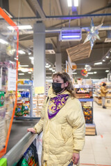 Fototapeta premium Woman in protective mask choosing groceries in supermarket