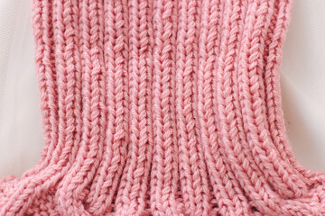 Pink knitted scarf on a white background