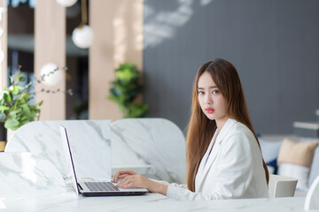 Beautiful business Asian woman is working seriously with computer notebook or laptop in the office.