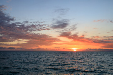 Fototapeta premium evening at sea, setting sun and clouds in the sky