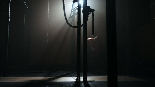 A woman throwing a ball up with squats in the gym. Silhouette of a woman throwing a ball over her head. Squats with a ball