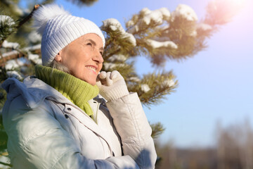 Beautiful senior woman posing in snowy winter park