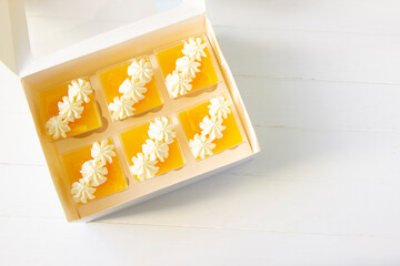 Orange  panna cotta in a portion cups, paper box, sweets delivery, citrus fruits dessert, low...