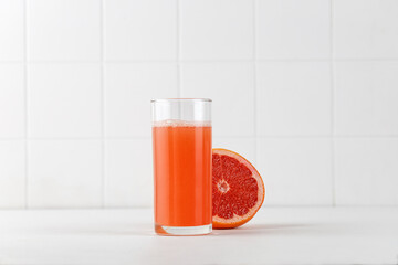 Mock up of Juice of grapefruit in glass. Freshly squeezed juice on white background. For packaging and menu