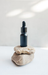 Glass dropper bottle with pipette on the stone. Cosmetic oil bottle mockup. Mockup scene. Product presentation concept.