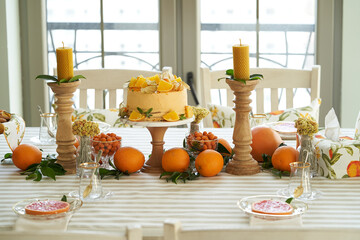 Table with orange cookies, fruits snacks.