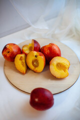 Ripe nectarines on   light background on   wooden tray