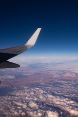 Fototapeta premium The wing of an airplane in the blue sky. Journeys. Flight. Airplane