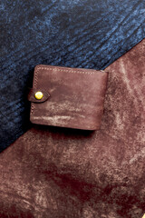 Brown wallet, made of genuine leather on a leather background