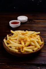 French fries on the table. Mayonnaise and ketchup in bowls