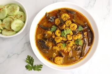 Tangy and spicy Shrimp curry. Tiny prawns curry made using dried mango and Indian spices. garnished with coriander and served with cucumber slices. Copy space.