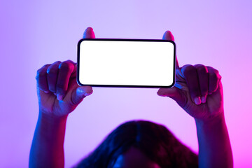 Unrecognizable young African American woman holding empty smartphone with mockup over her head in...