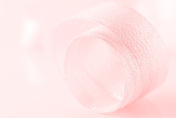 Gentle abstract macro of pink pastel color. Beautiful wedding background. Textile ribbon close up. Selective soft focus.