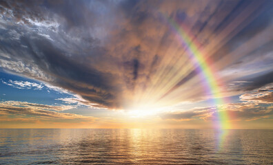 Calm sea before storm with amazing double sided rainbow at sunset   