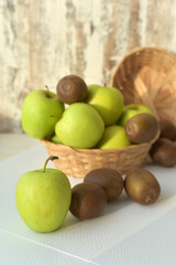 Juicy green apples and kiwi in a basket