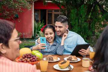 happy father watching video on mobile phone with child outside in the garden