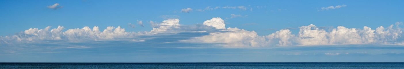 Panorama of sky with clouds over the sea horizon, nature background. Wide horizontal marine landscape with a beautiful sky for your weather banner or billboard. - 484643546