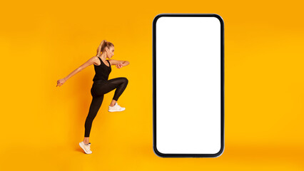 Fitness Woman Exercising Near Huge Phone Jumping Looking Aside, Studio