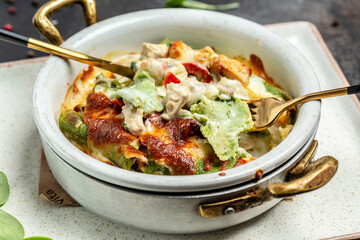 Mediterranean cuisine spinach crepes stuffed with chicken and mushrooms baked with cheese. Restaurant menu, dieting, cookbook recipe. top view