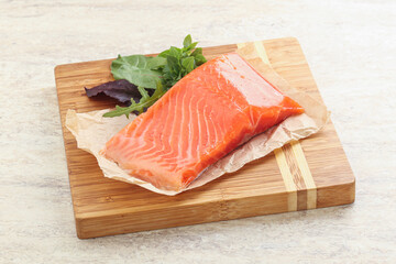 Raw salmon fillet over board