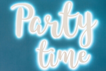 Party time neon sign on blue wall close up
