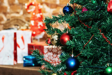 New Year's toys on a Christmas tree on a background of gifts