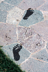 Wet footprints on a stone tile close up