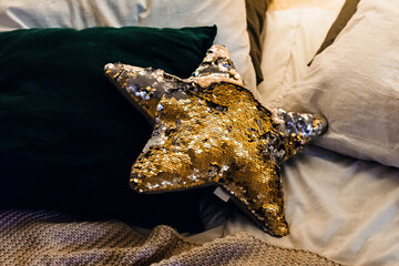 Yellow pillow in the form of a star on the bed