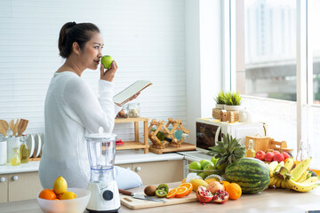 Asian middle-aged woman sniffed green apples and prepared fruits and vegetables for breakfast, healthy food at home