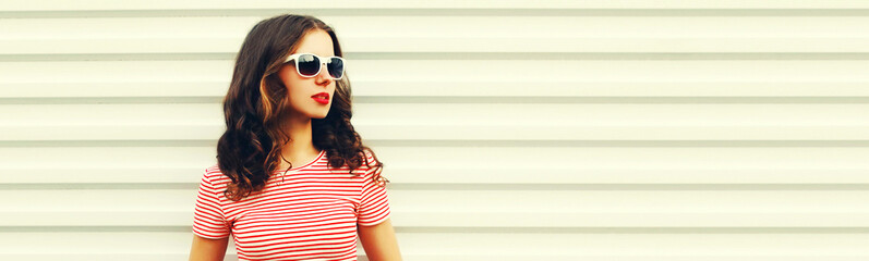 Portrait of beautiful brunette young woman looking away wearing sunglasses on white background